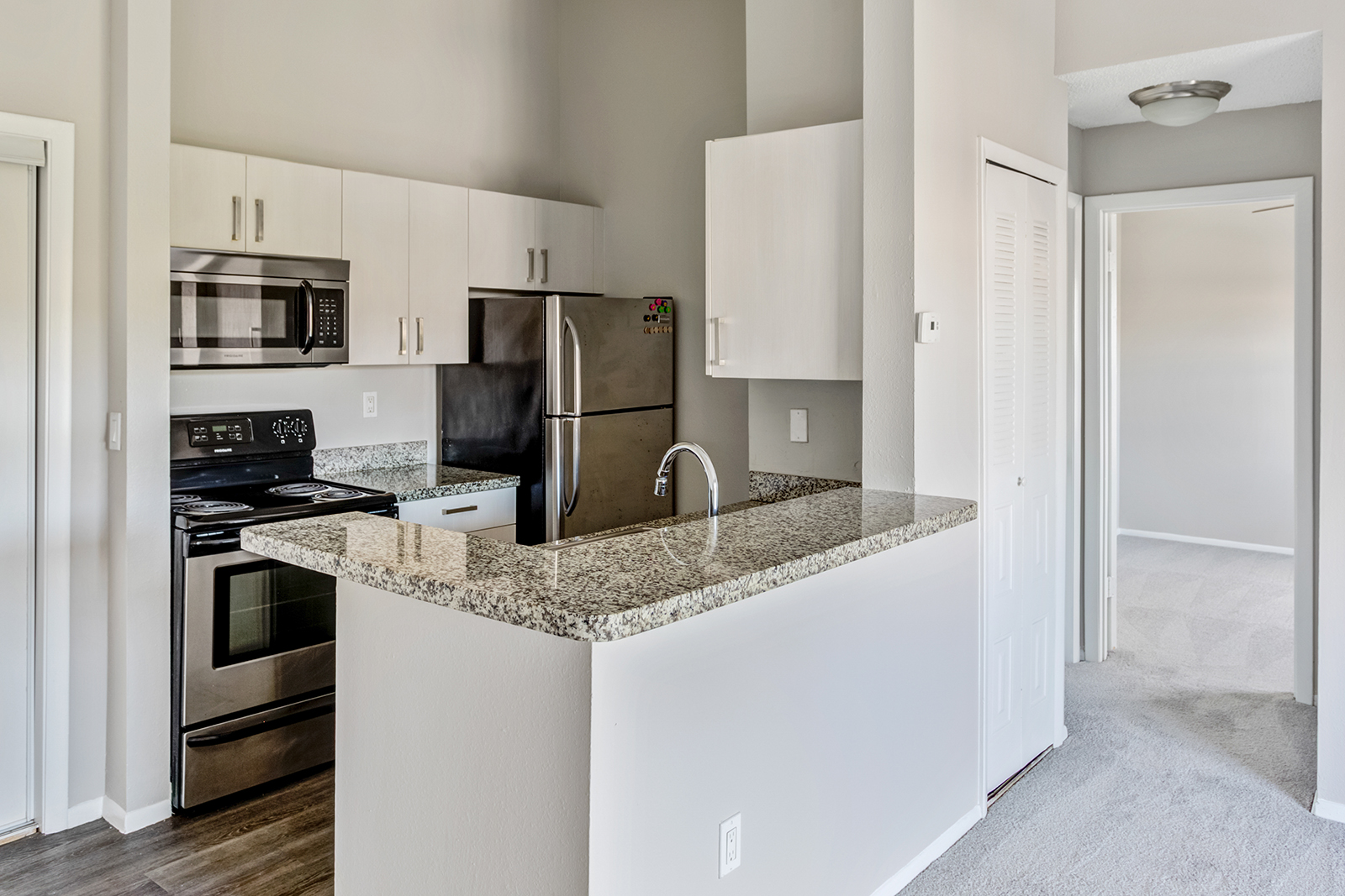 luxury key west apartment kitchen with stainless steel appliances and white cabinets